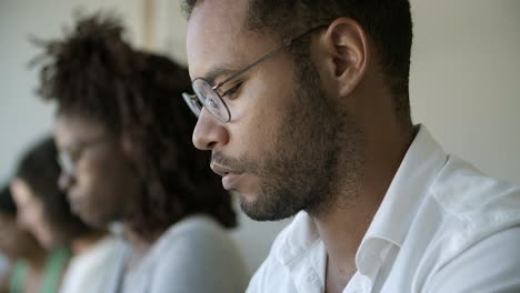 Fokussierter-Afroamerikanischer-Mann-Mit-Brille,-Der-Nach-Unten-Schaut